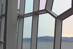 Ausblick durch die buntverglasten Fenster auf eine Bergkette