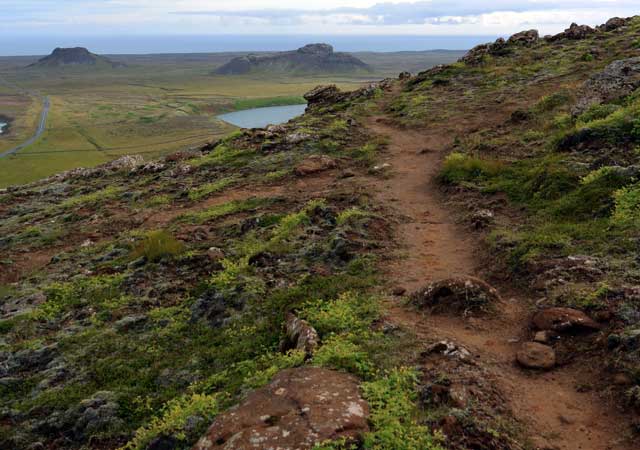 Ein schmaler Feldweg f&uuml;hrt den H&uuml;gel hinauf - Blick zum Meer und die Seen Gr&aelig;navatn und Gestssta&eth;avatn