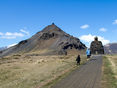 Die Bárðar Saga Snæfellsáss
                                        Statue und links dahinter der Stapafell bei Arnarstapi