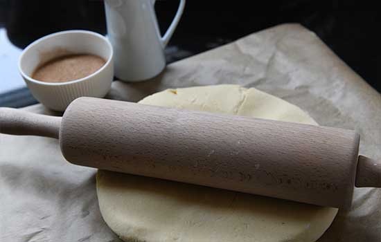 Den Teig  f&uuml;r die Kekse auf Backpapier ausrollen