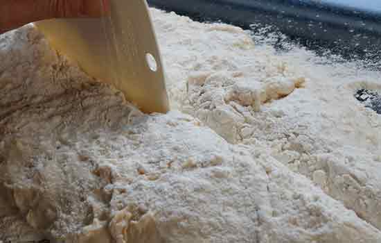 Mit einer Teigkarte den Teig in zwei Teile schneiden