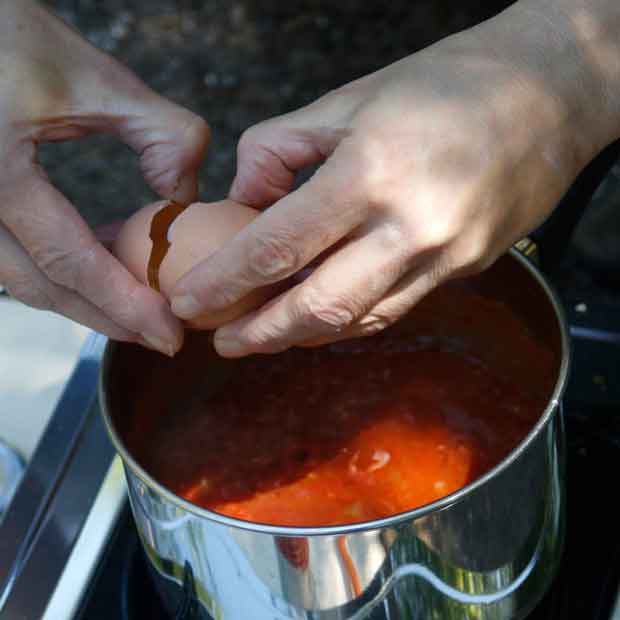 Shakshuka - die rohen Eier aufschlagen und in der Sauce verteilen