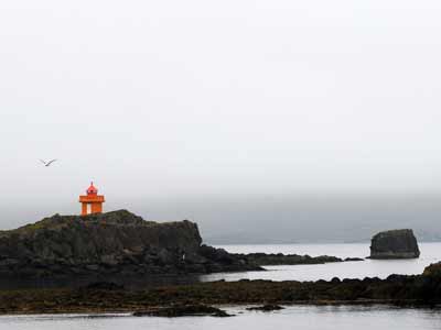 Der Leuchtturm jenseits des Hafens auf der &AElig;&eth;arsteinstanga