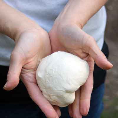 Den Hefeteig für das Naan mit der Hand kneten bis er schön geschmeidig ist